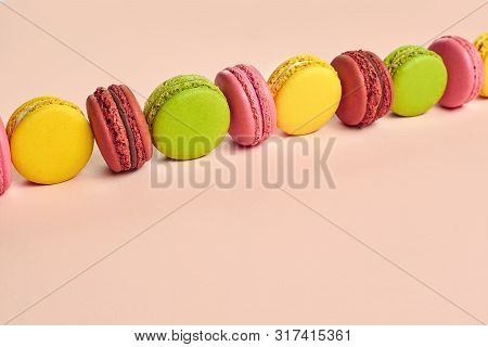 Colored Macaron Or Macaroon, Sweet Meringue-based Confection On Pink Background. Close-up, Copy Spac