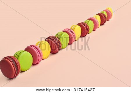 Colored Macaron Or Macaroon, Sweet Meringue-based Confection On Pink Background. Close-up, Copy Spac