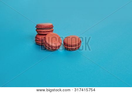 Colored Macaron Or Macaroon, Sweet Meringue-based Confection On Blue Background. Close-up, Copy Spac