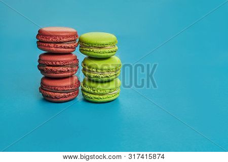 Colored Macaron Or Macaroon, Sweet Meringue-based Confection On Blue Background. Close-up, Copy Spac