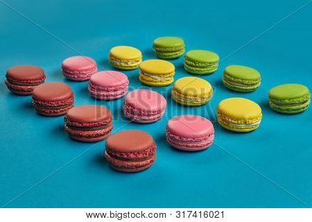 Colored Macaron Or Macaroon, Sweet Meringue-based Confection On Blue Background. Close-up, Copy Spac