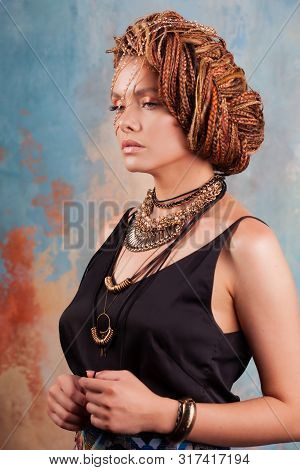 Southern Flavor. Portrait Of A Luxurious Tanned Woman, Pensive, Stylish, With An Exotic Hairstyle An
