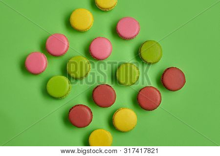 Colored Macaron Or Macaroon, Sweet Meringue-based Confection On Green Background. Close-up, Copy Spa