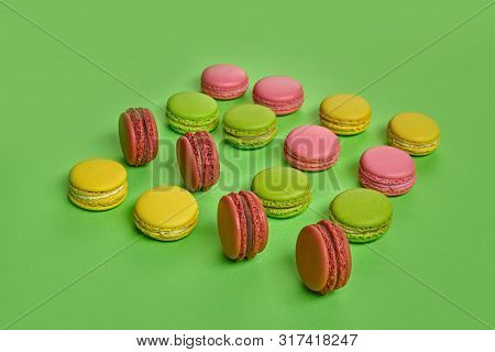 Colored Macaron Or Macaroon, Sweet Meringue-based Confection On Green Background. Close-up, Copy Spa