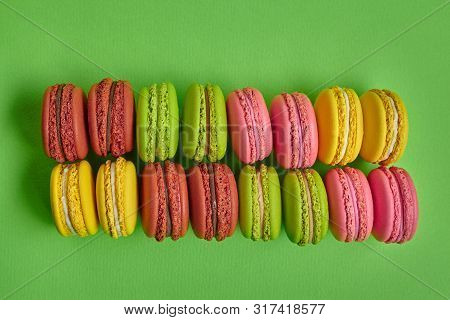 Colored Macaron Or Macaroon, Sweet Meringue-based Confection On Green Background. Close-up, Copy Spa
