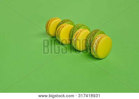 Colored Macaron Or Macaroon, Sweet Meringue-based Confection On Green Background. Close-up, Copy Spa