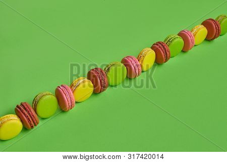 Colored Macaron Or Macaroon, Sweet Meringue-based Confection On Green Background. Close-up, Copy Spa