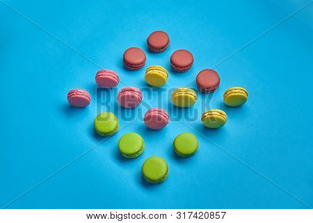 Colored Macaron Or Macaroon, Sweet Meringue-based Confection On Blue Background. Close-up, Copy Spac