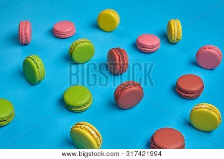 Colored Macaron Or Macaroon, Sweet Meringue-based Confection On Blue Background. Close-up, Copy Spac