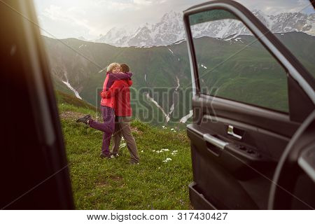 Happy Couple Hugs On Beautiful Nature And Mountains Out Of Car