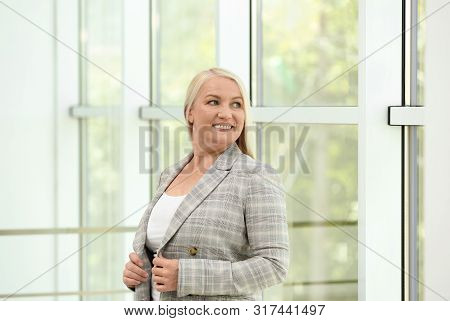 Portrait Of Happy Mature Woman Near Window Indoors