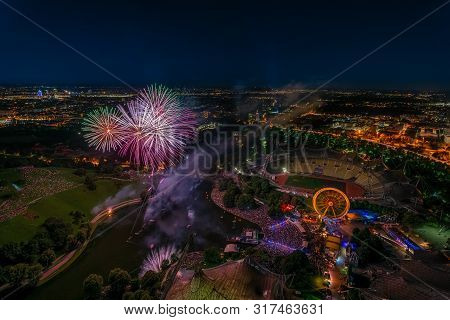 Aerial Panoramic Cityscape View With Bright Fireworks Lights In Night Munich.