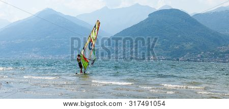 Lake Como, Italy - July 21, 2019. Water Sport: Windsurfer Surfing Wind Bright Sunny Summer Day Near 