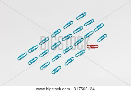 A Bunch Of Blue Paperclips Aligned And One Red Paperclip Nonaligned On White Background , Shot From
