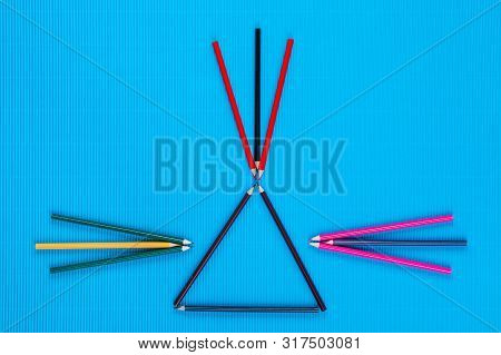 A Bunch Of Crayons Forming Arrows On An Blue Background, Shot From Above.