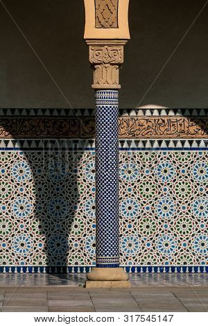 Oriental Looking Columns With Blue Mosaic Pattern And A Tiled Floor With Oriental Patterns