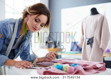 Fashion Designer Woman Working With Ipad On Her Designs In The Studio