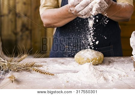 Womens Hands, Flour And Dough. Levitation In A Frame Of Dough And Flour. A Woman In An Apron Is Prep