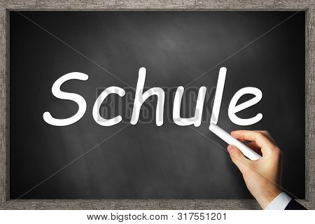 Hand Writing Schule (engl. School) On Black Chalkboard