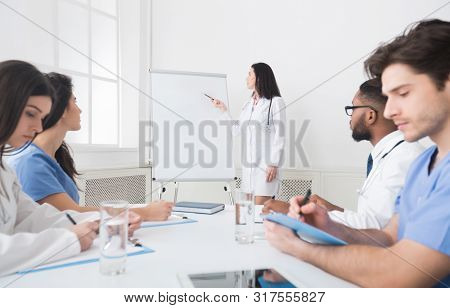 Medical Lecture. Cardiologist Telling Theory To Interns Using Whiteboard With Pictures