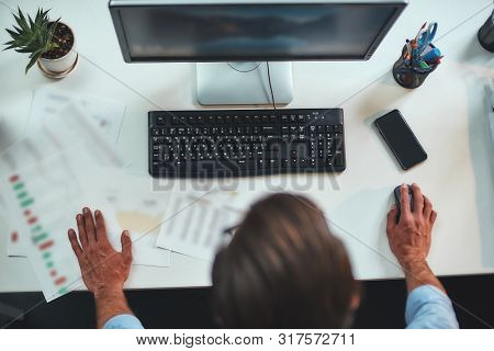 Busy Working Day. Top View Of A Businessman Working On The Computer While Standing In The Office