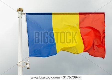 Flag Of Roumania On A Flagstuff In Front Of The Sky