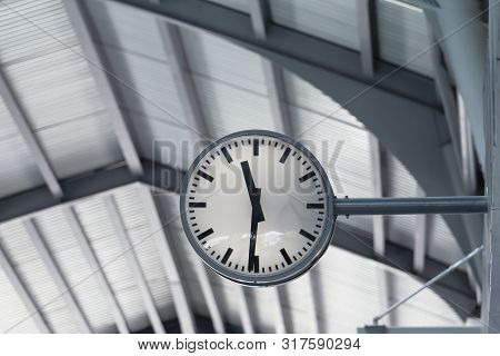 Public Clock In Railway Station At The Hanging With Roof Of Subway Central Train Station. It Is Cloc