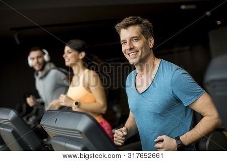 Young People Using Threadmill In Modern Gym