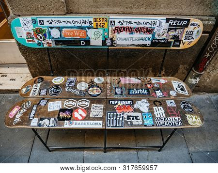 Barcelona, Spain - Nov 14, 2017: Multiple Trendy And Cool Stickers On The Bench Made From Skate Plan