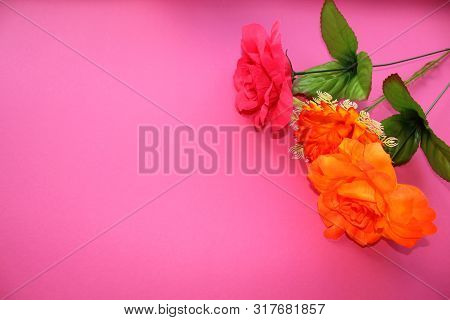 Three Beautiful Flowers On A Pink Background. Artificial Roses.