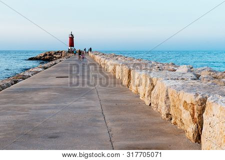 Denia, Spain - June 27, 2019: The Breakwater Of The Harbour Of Denia At Sunset
