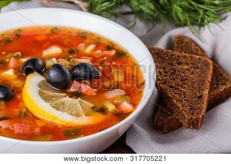 Traditional Russian Meat Soup Solyanka In Bowl On Rustic Wooden Table
