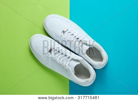 Fashionable White Sneakers On A Two-tone Background. Top View