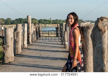 Horizontal Picture Of Beautiful Asian Eye Model Posing At U Bein Bridge, A Landmark Of Mandalay, Mya