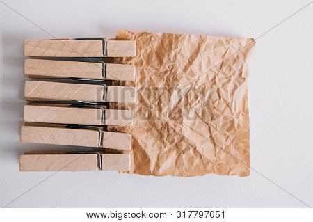 Woodenl Clothespins, Paper Clip And Brown Sticker On White Background. Isolated On White. View From 