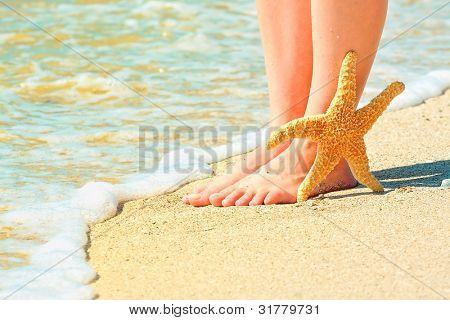 pigens barfodet ben på en sandstrand