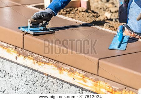 Construction Worker Using Hand Groover On Wet Cement Forming Coping Around New Pool.