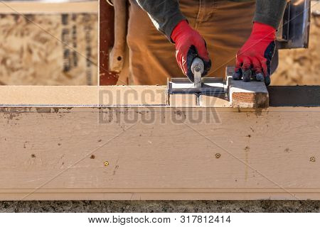 Construction Worker Using Hand Groover On Wet Cement Forming Coping Around New Pool.