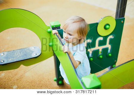 Adorable Toddler Girl Having Fun On Playground. Outdoor Activities For Kids