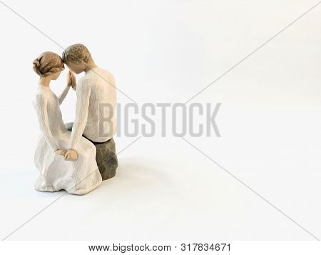 The Figure Of A Couple In Love. The Statuette He And She - Love. A Man And A Woman Are Sitting, Hugg