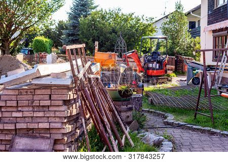 Construction Sites Warehouse With Excavator, Iron Grid, Paving Stones, Ramp And Crane Bucket.