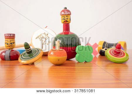 Colourful Different Types Of Gi Tagged Channapatna Toys On Table With Isolated Background.