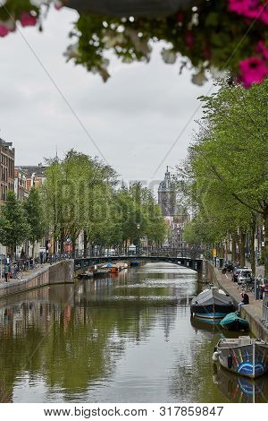 Saint Nicholas Church Is Landmark Of Amsterdam In Netherlands, Unique With City Scene Along Canal In
