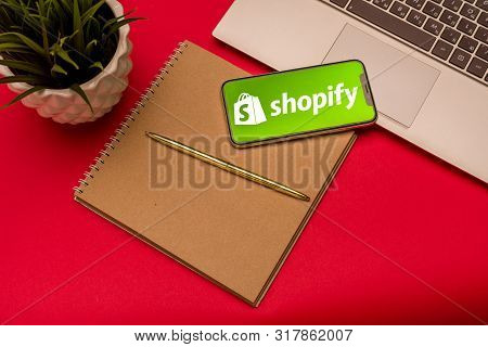Tula, Russia - August 19, 2019: Shopify Logo On Iphone X On Keyboard Laptop On Red Bsckground