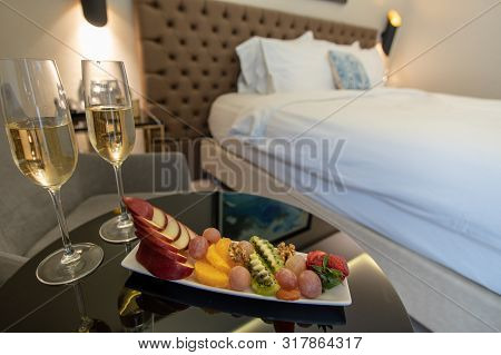 Champagne Glasses And Fruit Salad In Hotel Room