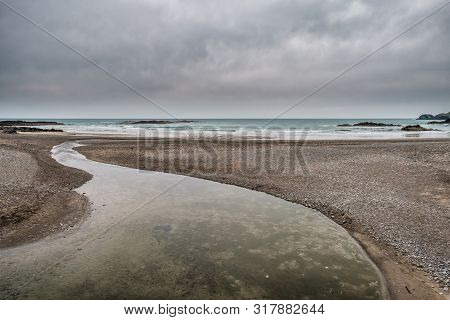 A Small River Joins The Sea At Owenahincha Beach In County Cork On The South West Coast Of Ireland