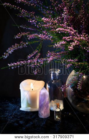 Flasks, Crystal, Candle And A Bouquet Of Heather. Mystical Still-life.