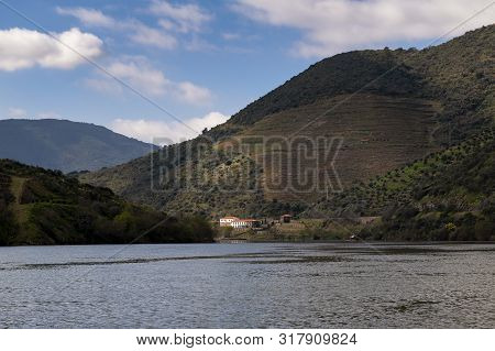 Scenic View Of The Douro River With A Traditional Rabelo Boat And Terraced Vineyards Near The Tua Vi