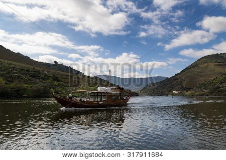 Tua, Portugal - March 3, 2019: Tourist In A Traditional Rabelo Boat At The Douro River Near The Vill