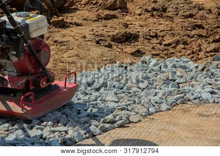 Rammer At Work. Rammer Rubble On The Edge Of The Road. Construction Work On The Road